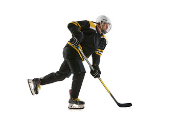 Obraz premium Young man wearing black and yellow uniform, hockey player in motion with stick during game isolated on white background. Concept of professional sport, competition, game, tournament