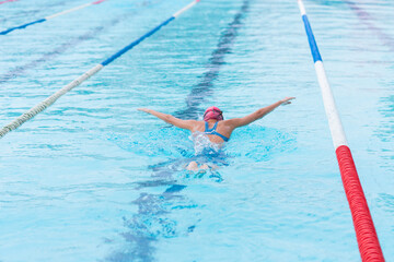 young girl athlete swimmer swims at competitions butterfly. Water sports and competition, learning...