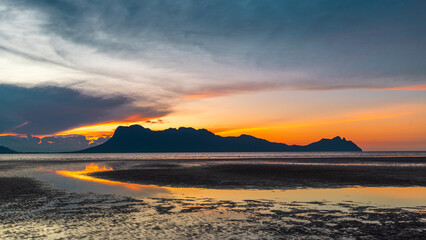 Sunset on the beach in Bako National Park, Borneo, Malaysia, Fiery colors of the sky, low tide of the sea and view of Mount Santubong - 786414655