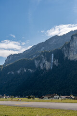 Waterfall in countryside in Swizterland on bright sunny day. Swiss Alps mountain region.