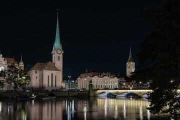 Fraumunster Church at night in Zurich, Switzerland. Lights on a bridge