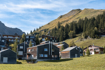 Fototapeta na wymiar Mountain huts in Stoos village in Switzerland. Swiss Alps ski resort in autumn or fall
