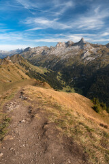 Swiss Alps mountain range seen from summit of Klingenstock, Switzerland. Hiking trail on a ridge