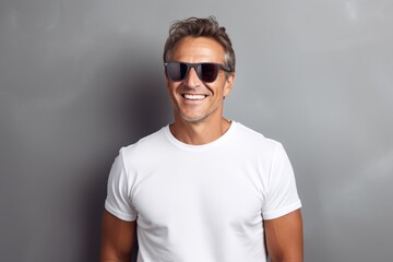 Portrait of a grinning man in his 40s wearing a trendy sunglasses isolated on modern minimalist interior