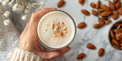 Hand Holding Almond Milk Smoothie Against Neutral Background