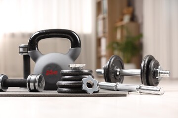 Many different sports equipment on floor indoors