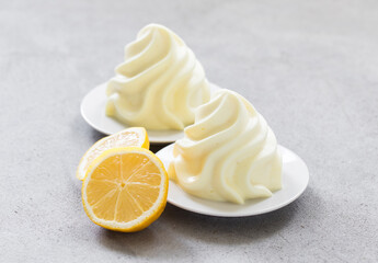 Modern dessert.  Lemon cream pudding, Panna Cotta in the form of French Chantilly cream. Light grey background. Close-up