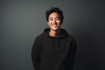 Portrait of a happy asian man in his 20s dressed in a comfy fleece pullover isolated on modern minimalist interior