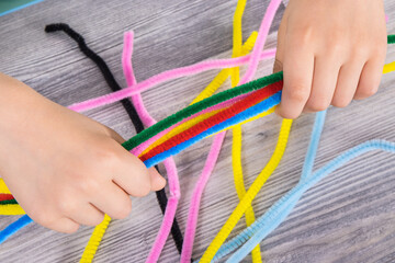 Preschooler hands with creative sticks used to learn counting, colors and arranging various shapes....