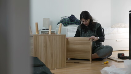 Furniture Assembly Expertise Captured - Spirited Woman Building Nightstand, Emphasizing DIY...