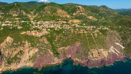 Aerial view of the small village of Nebida, in the municipality of Iglesias, province of Southern Sardinia, Italy. In foreground there are the remains of the washery of the Nebida mine. - obrazy, fototapety, plakaty