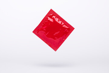 red condom floating in the air isolated on a gray background, protection, contraceptive and safe...