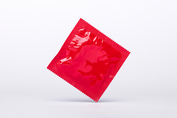 red condom floating in the air isolated on a gray background, protection, contraceptive and safe...
