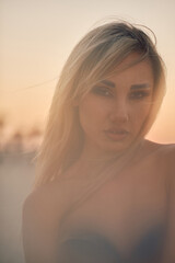 An alluring woman gazes into the camera through a hazy, dreamlike soft focus, with warm hues and an...