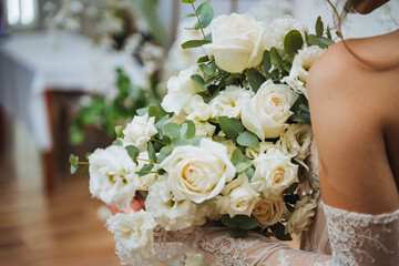 Bride holding bouquet of white roses, a classic wedding ceremony supply
