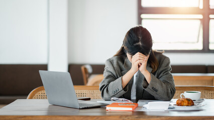 Overwhelmed female professional with headache at her workplace, papers and laptop on table,...