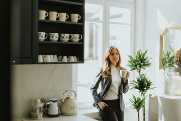 Businesswoman enjoying a morning coffee break in a sunlit modern kitchen