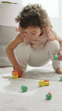 4K vertical slow motion video of a girl playing with balance blocks on a sustainable wooden toy. Montessori methodology and materials. education, development and learning in the childhood stage