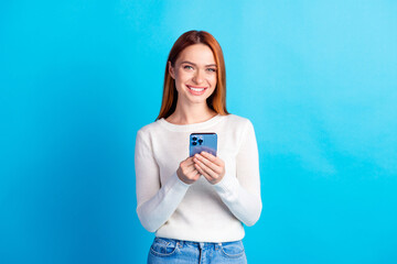 Photo portrait of attractive young woman hold device dressed stylish white clothes isolated on blue color background
