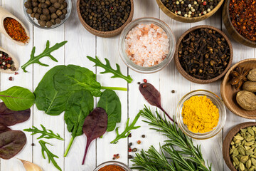 Spices and fresh herbs on a white wooden background. Top view.