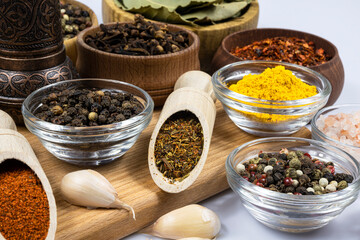 Assortment of oriental spices in glass and wooden dishes.