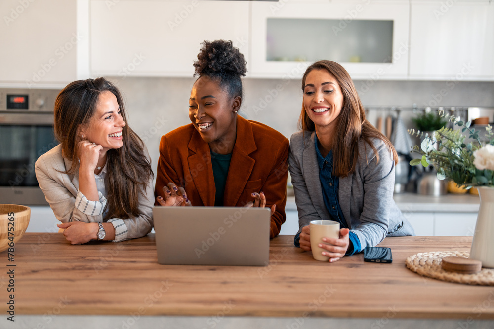 Wall mural African woman talking to her friends while using laptop and having a meeting in her home office.