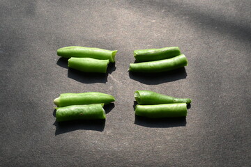 Green beans on black background. Its other names names French beans, string beans, snap...