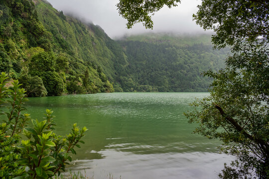 Fog coming down a hill with green vegetation in Sete Cidades lagoon, São Miguel - Azores PORTUGAL