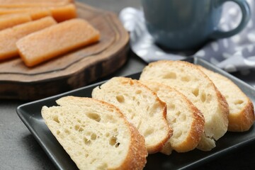 Delicious quince paste and bread on grey textured table, closeup