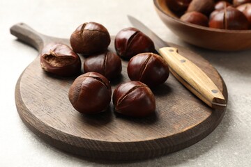 Fresh edible sweet chestnuts on grey table, closeup