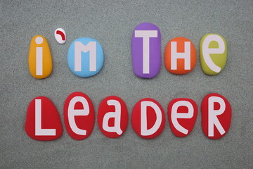 I am the leader, motivational slogan composed with hand painted multi colored stone letters over...