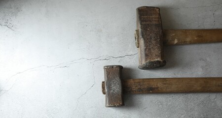 Two sledgehammers on grey background, top view. Space for text