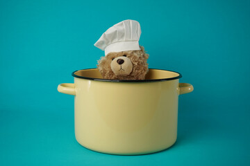 Chef's hat, plush teddy bear in a bowl.  
