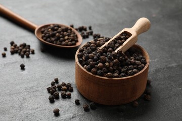 Aromatic spice. Pepper in bowl and scoop on black table