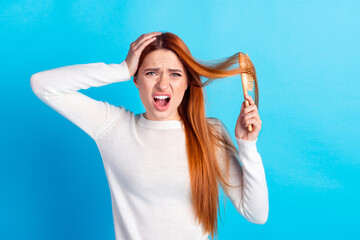 Photo portrait of attractive young woman hair comb shocked frightened dressed stylish white clothes isolated on blue color background