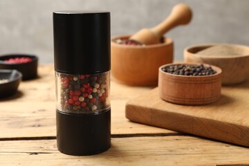 Different peppercorns on wooden table, closeup. Space for text