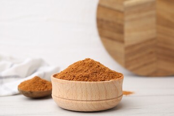 Aromatic spice. Ground red pepper in bowl on white wooden table, closeup