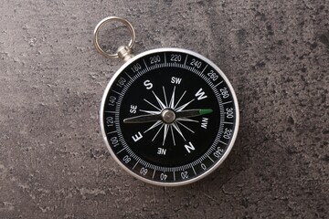 One compass on grey table, top view. Tourist equipment