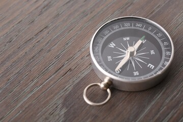 One compass on wooden table, space for text. Tourist equipment