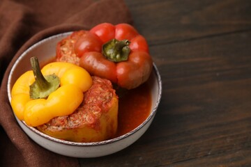 Delicious stuffed bell peppers on wooden table. Space for text