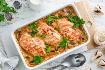 Baked chicken breast bbq with mushrooms and garlic in cream sauce on white wooden table...