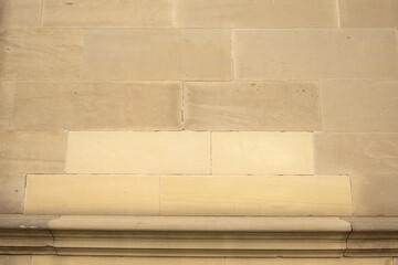 Close up of sandstone block wall on building with new replacement blocks