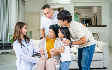 Big family and female doctor taking portrait photo together to encourage grandmother who get sick or cancer, smiling with happiness, staying at home. Healthcare, Retirement Concept.