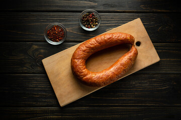 Sausage on a cutting board with spices and pepper in a restaurant. Meat food concept with smoked...