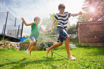 Kids immersed in water game on open air, with sunny backyard