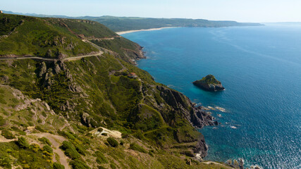 Aerial view of Plagemesu beach located in the municipality of Gonnesa, in southern Sardinia, Italy. The coast is characterized by steep mountains that descend to the sea.