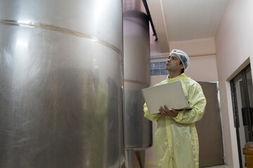 Winemaker inspecting quality the process of fermentation during manufacturing in winery factory and...