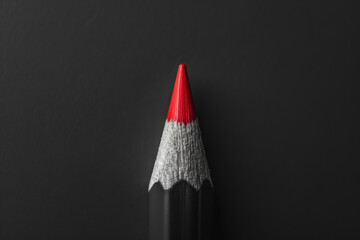 macro shot of a sharp red pencil tip against a black background