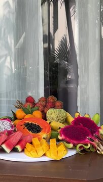 Fresh fruit plate and set of summer fashionable beach accessories, top view Tropical beach lifestyle.Plate . fruit on the hotel porch 
