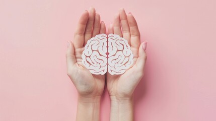 Hands holding brain paper cutout on pink background World mental health celebration